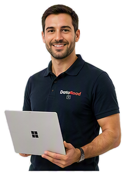 Smiling man in a navy polo shirt holding a silver laptop with a Windows logo.