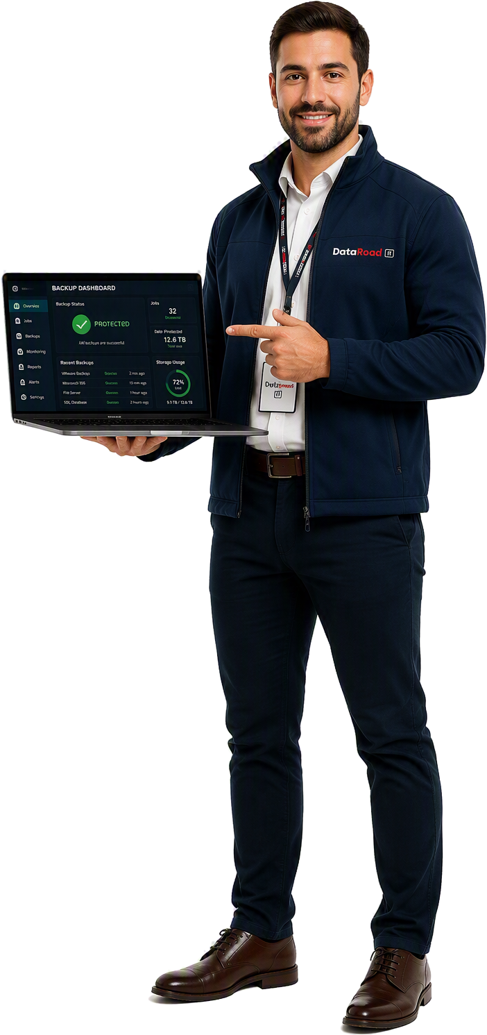 Professional man in a navy DataRoad jacket presents a laptop screen showing a backup dashboard with a green 'Protected' status and system stats.